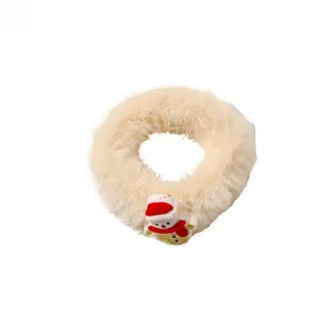 Detail view of a soft cream plush scrunchie featuring a cute 3D Christmas snowman charm