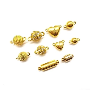 Detail of assorted gold magnetic clasps in heart and bead shapes for jewelry making