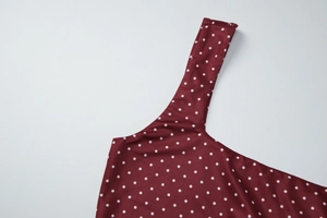 Dettaglio dello scollo e della spallina sul crop top attillato a pois rossi e bianchi
