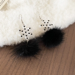 Detailed view of winter acrylic flower earrings with soft black plush fur pompoms