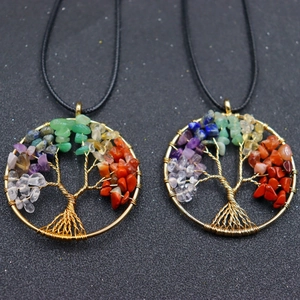 Detail of handmade gold wire life tree necklace with colorful natural chakra stones