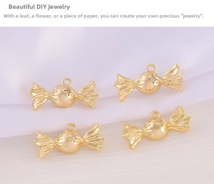 Close-up of four gold candy-shaped pendants with small inset crystals on white silk