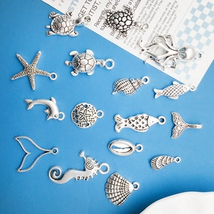 Antique silver sea animal pendants collection featuring turtles and starfish on blue surface