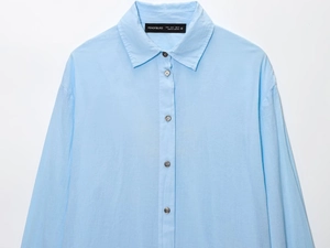 Detail of light blue button-up shirt featuring collar label and ruched texture fabric