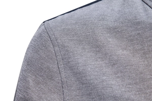 Close-up of Oxford shirt shoulder seam showing double-stitched details and grey fabric