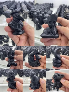 Close-up of matte obsidian puppy and animal figurines showing detailed hand-held textures