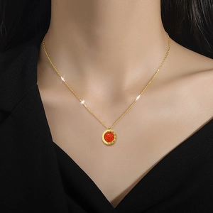 Golden Roman numeral necklace with round red gemstone pendant on elegant black background