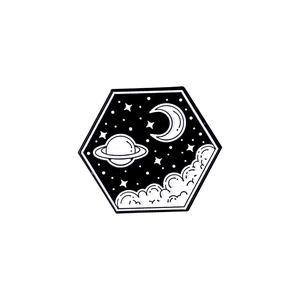 Detail of hexagonal enamel pin featuring minimalist black and white space planet illustration