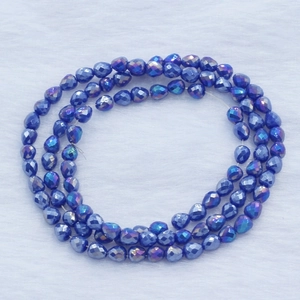 Blue iridescent strawberry faceted teardrop beads for DIY jewelry making on white fur