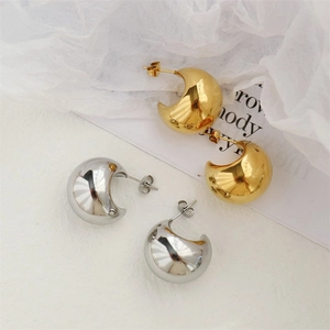 Minimalist thick C-shape hoop earrings in polished gold and silver finishes on white fabric
