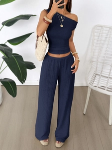 Detail of navy blue two-piece set featuring textured pleat fabric and wide leg trousers