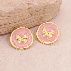 Gros plan de boucles d'oreilles papillon vintage avec émail rose et détails dorés