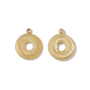Macro detail of round golden textured steel charms for DIY jewelry pendants