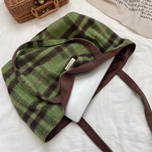 Plaid wool tote bag showing large capacity with a laptop inside on a soft background