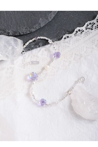 Macro shot of S925 sterling silver bracelet with purple crystals and pearls on lace