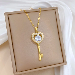 Macro shot of gold heart-shaped key pendant with sparkling crystal and chain detail