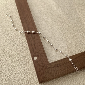 Bracciale in argento 925 con perline sfumate e chiusura a moschettone su legno