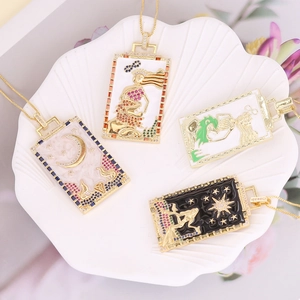 Macro shot of 18K gold plated rectangular tarot pendants with zircons on a shell plate
