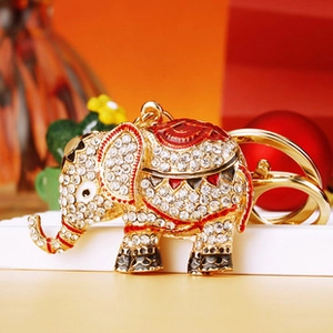 Detailed close-up of a crystal elephant keychain with gold plating and red enamel accents