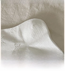 Detail of reinforced heel on white knit cotton crew socks with durable texture
