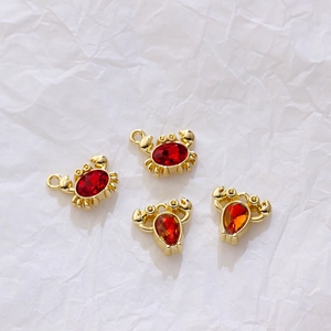 Detailed view of gold crab and lobster pendants with zircon stones for DIY jewelry