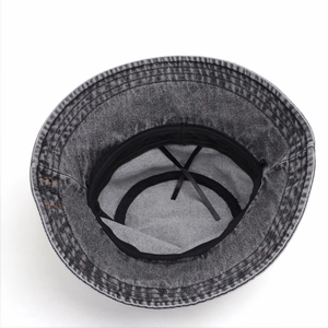 Dettaglio dell'interno del cappello a secchiello in denim con laccio regolabile e cuciture extra