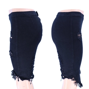 Detail eines schwarzen Jeans-Midirocks mit seitlichen Rissen und ausgefranstem Saum