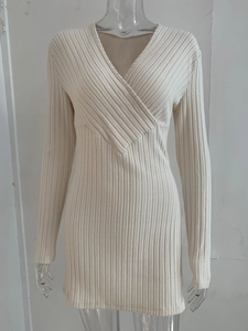 Detail of cream long-sleeve ribbed knit dress featuring a deep V-neckline design