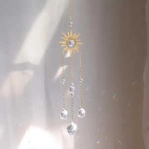 Golden sun suncatcher with crystal prisms reflecting rainbow light on a soft background