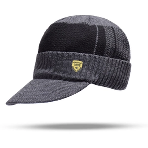 Detailed texture of thick rib-knit dark gray winter hat with yellow brand patch