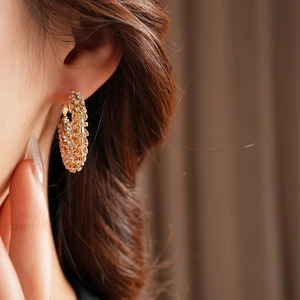 Close-up of gold hollow hoop earrings with pave-set shimmering crystals for women