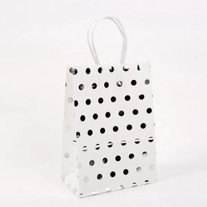 White kraft paper gift bag with silver polka dots and twisted paper handles for shopping