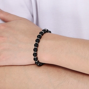 Close-up of black beaded bracelet with silver metal spacers on a model wrist