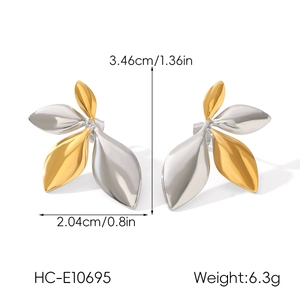 Detail view of leaf earrings in gold and silver with dimensions 3.46cm by 2.04cm