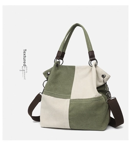 Detail of canvas tote bag with olive green and beige panels and brown straps
