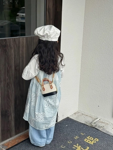 Outdoor-Aufnahme einer Mini-Muschel-Umhängetasche für Kinder kombiniert mit Blumenkleid