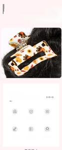 Detailed view of an autumn themed hair claw with pumpkin and sunflower patterns in hair