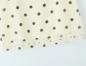Detail of polka dot chiffon fabric showing delicate ruffles and soft texture
