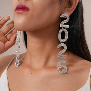 Close-up of dangling silver earrings featuring 2026 numerals with sparkling rhinestones