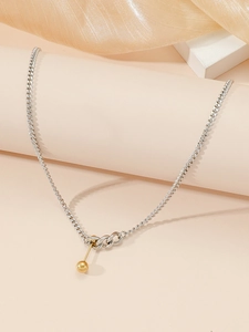 Detailed close-up of a silver-toned thin chain with a golden spherical dumbbell pendant