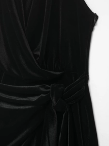 Detailed close-up of a black velvet dress featuring wrap waist design and side zipper