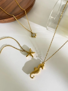 Vue détaillée de pendentifs hippocampe, étoile de mer et étoile sur colliers dorés