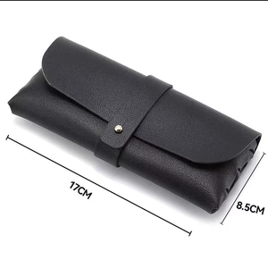 Minimalist black leather sunglass case with textured finish and snap button closure