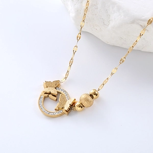 Elegant gold butterfly layered necklace with crystal accents on a white marble background