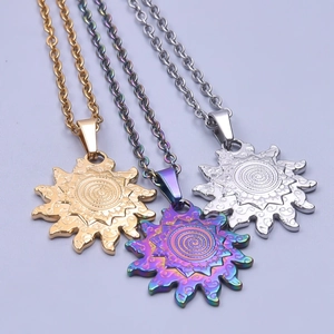 Three sunburst stainless steel necklaces in gold, silver, and rainbow finishes on blue surface
