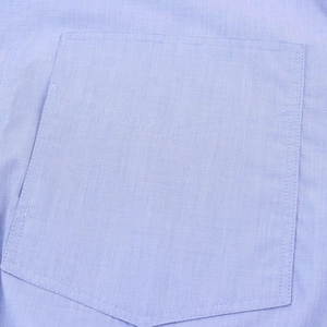 Dettaglio macro di una tasca di camicia azzurra con cuciture di alta qualità e trama twill