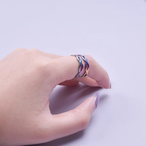 Close-up of rainbow titanium steel double twist ring on finger with colorful finish