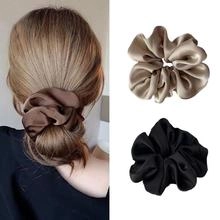 Detailed texture of glossy satin silk scrunchies in brown, champagne and black colors