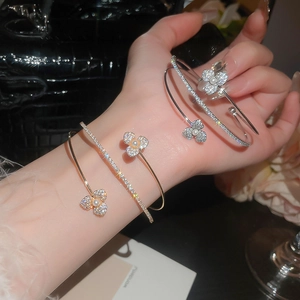 Detailed view of zircon flower bracelets with pearls in gold and silver finishes