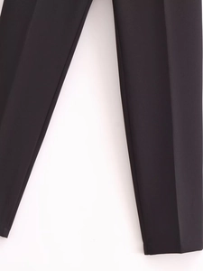 Detail shot of black high-waisted dress pants showing fabric texture and clean leg cut